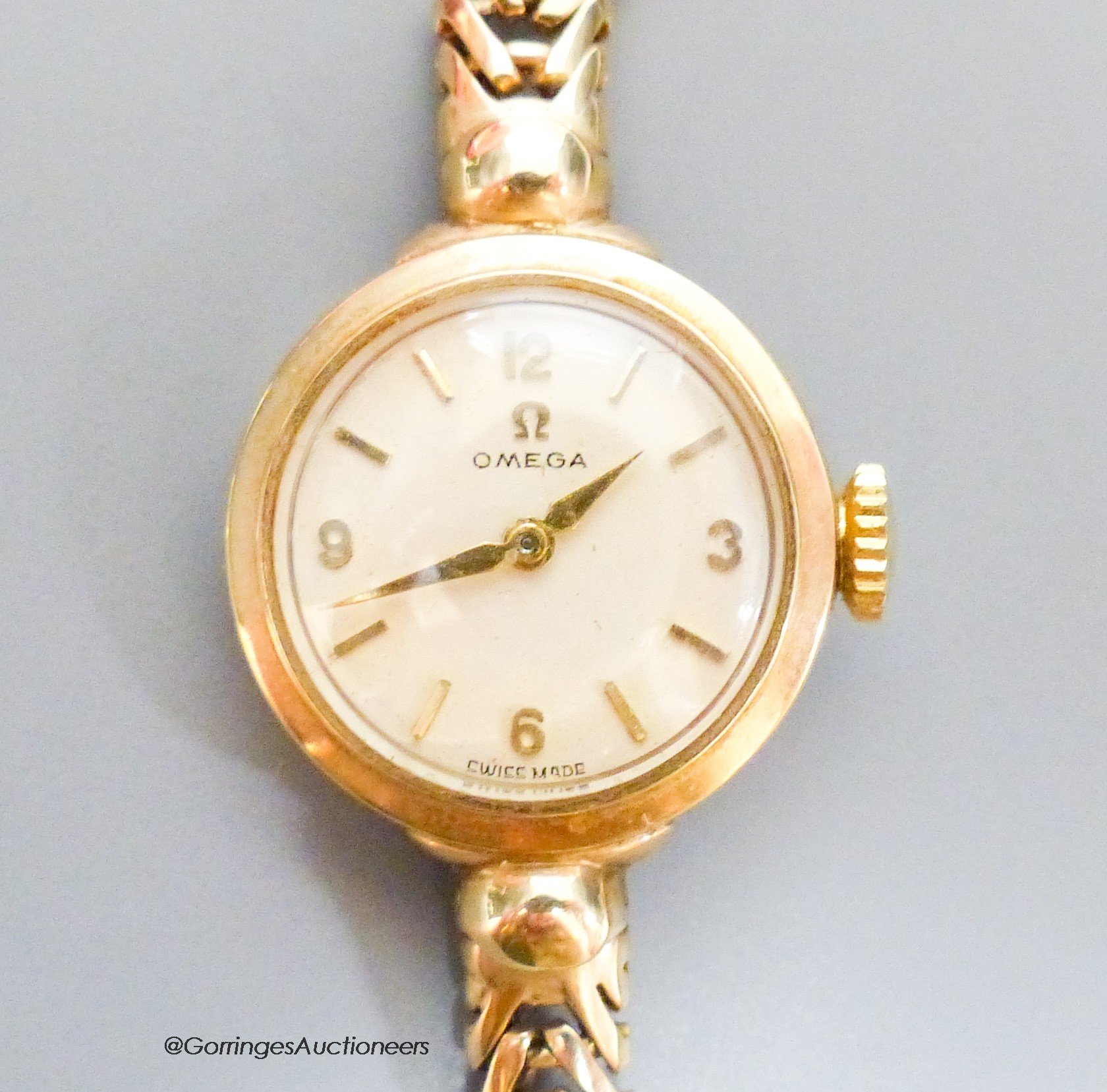 A lady's 9ct gold Omega manual wind wrist watch, on a 9ct gold bracelet, case diameter 20mm, gross 17.6 grams., with Omega box.